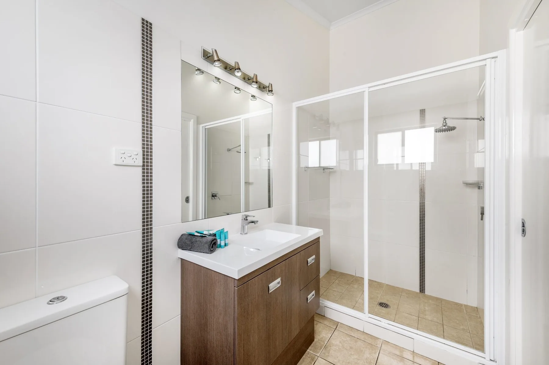 Ensuite with a long vanity, a wide mirror and a glass shower