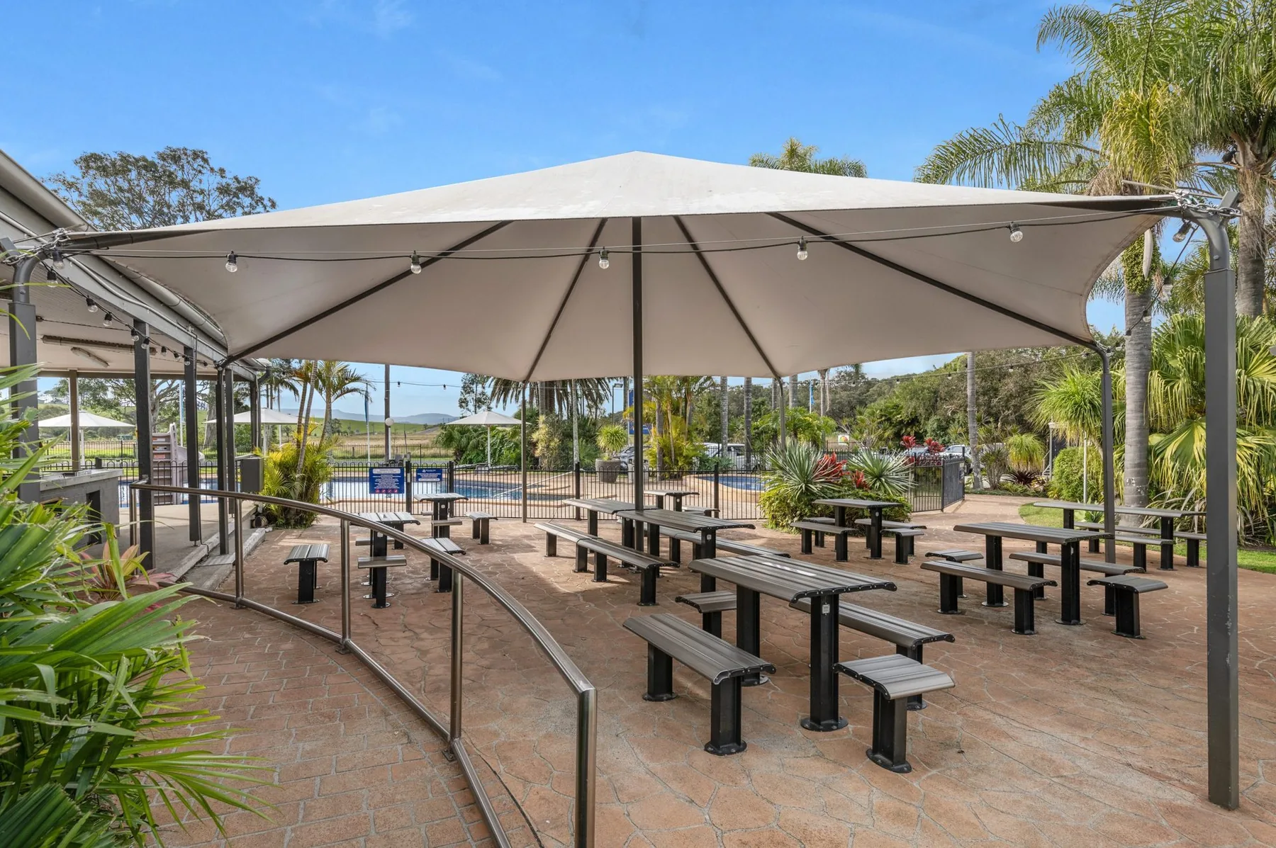 Picnic tables and bench seating under a white marquee