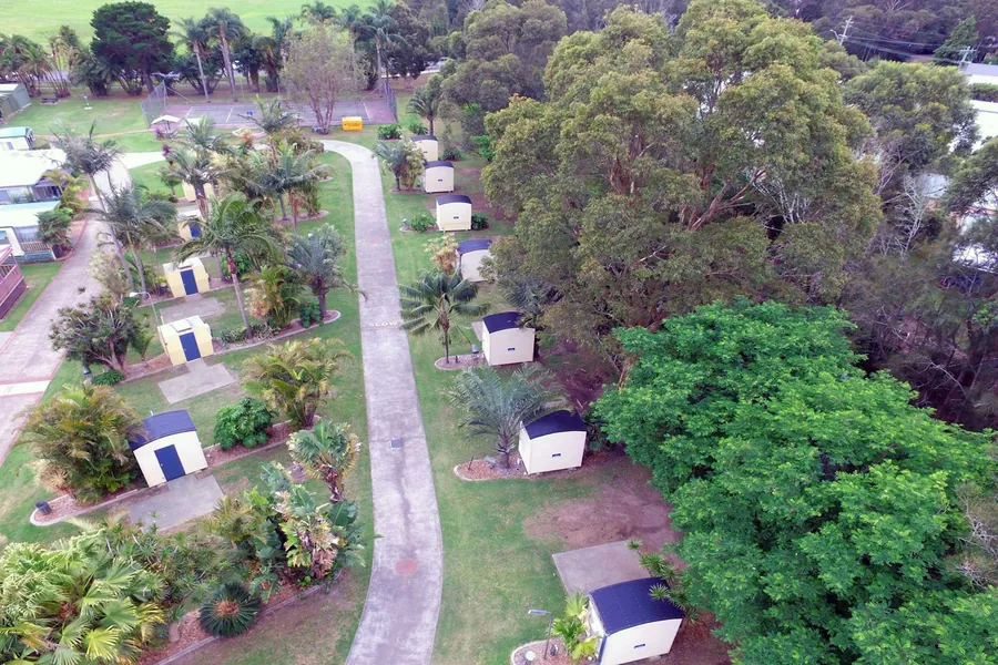 Aerial view down the park road, en-suite huts and vans set among the trees
