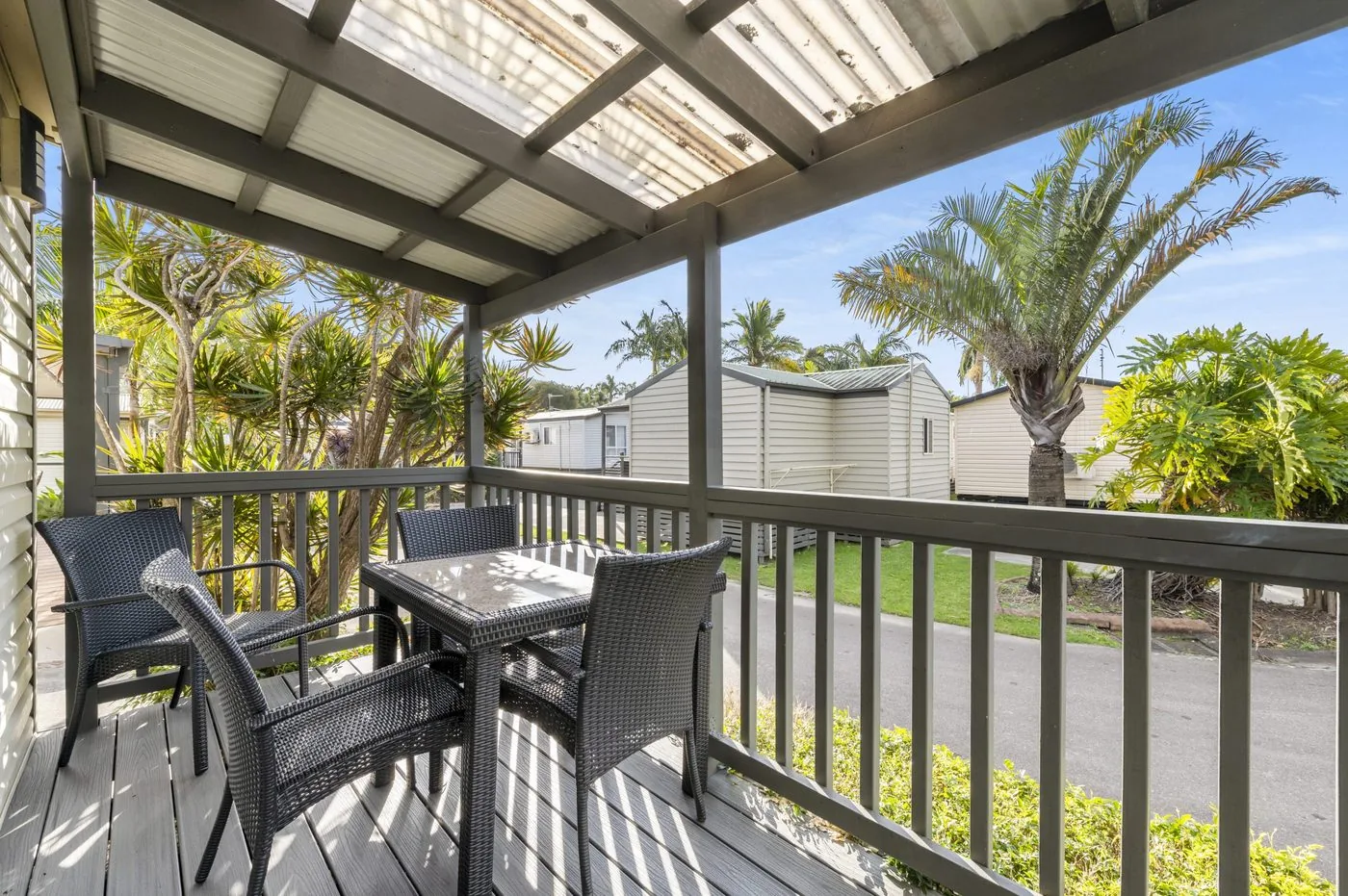 Undercover verandah with a table and four chairs looking out to a palm