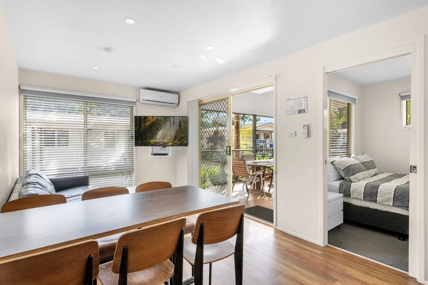 Dining table set for six with the bedroom doorway beyond