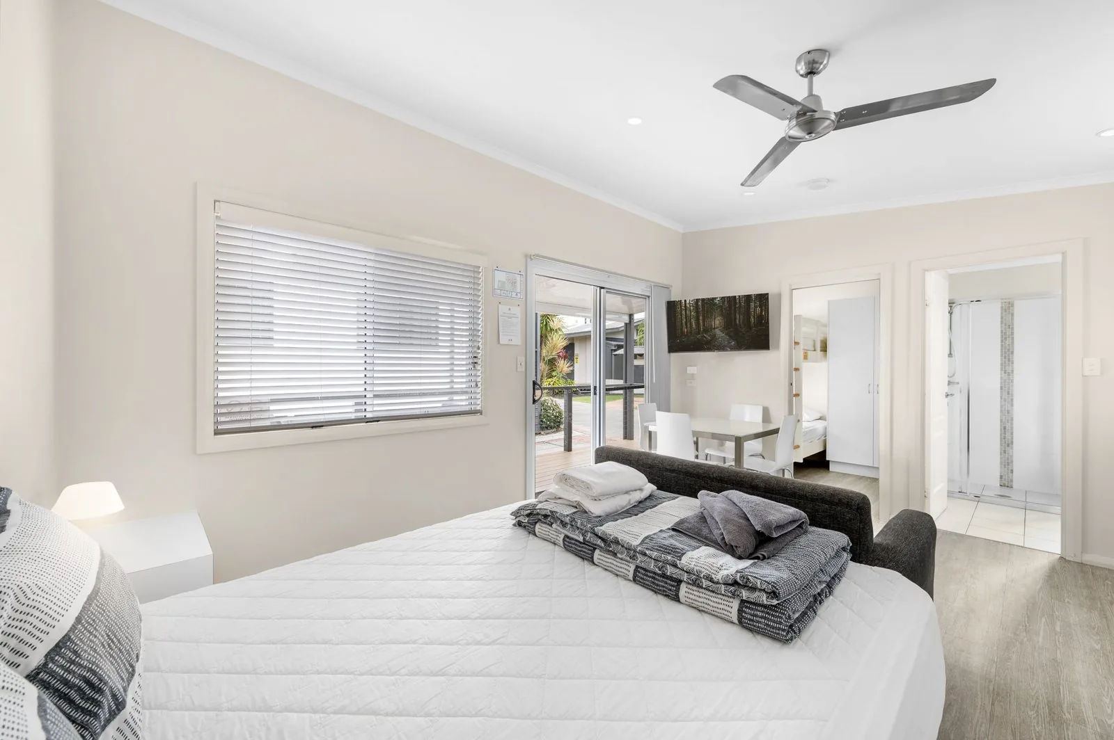 Open living area with a queen bed, a sofa and a ceiling fan