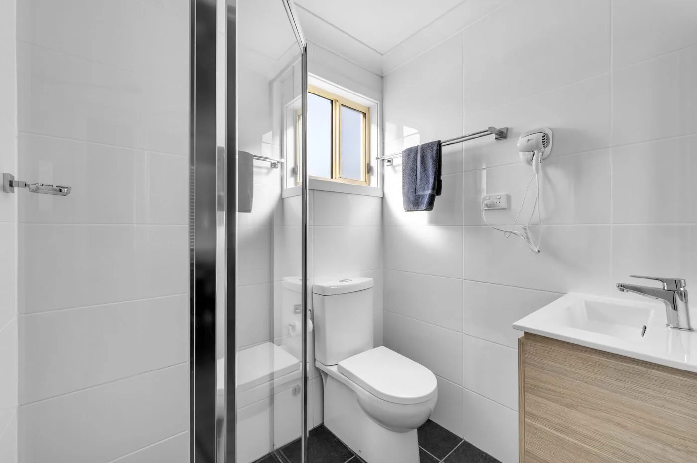 Bathroom with a walk-in shower, basin and a wall-mounted heater
