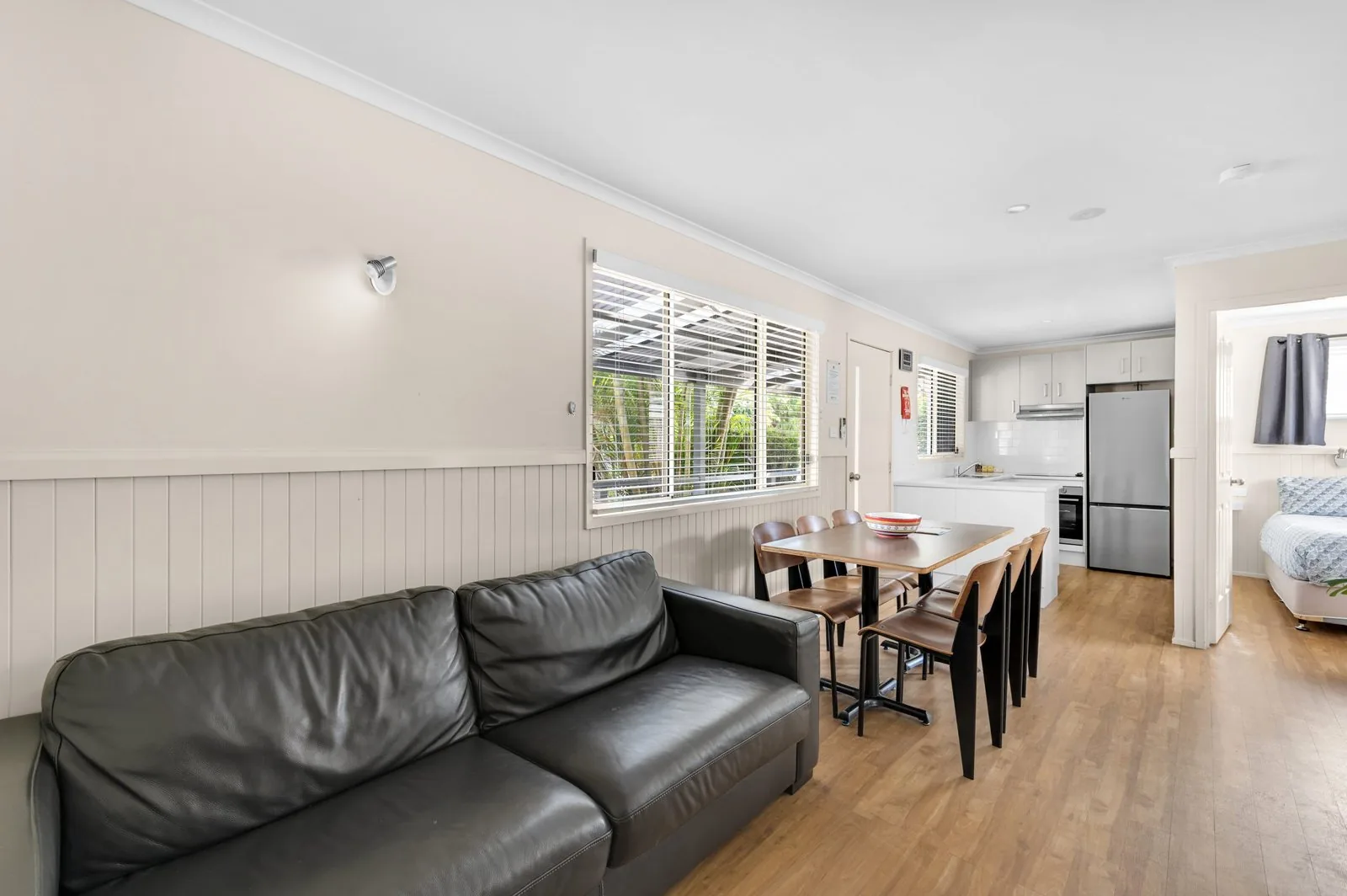 Lounge with a leather sofa and the dining table and kitchen beyond