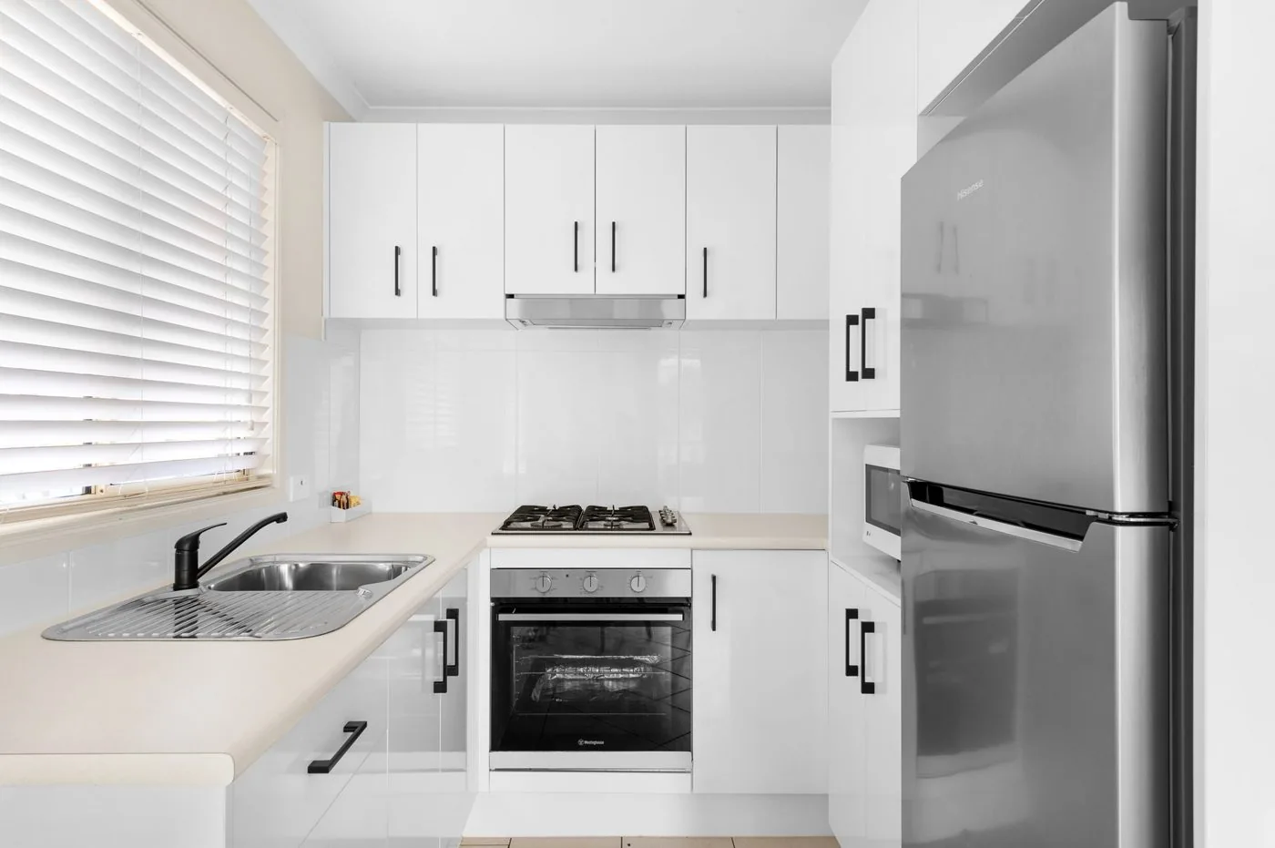 Kitchen with a gas cooktop, oven and a double sink under the window
