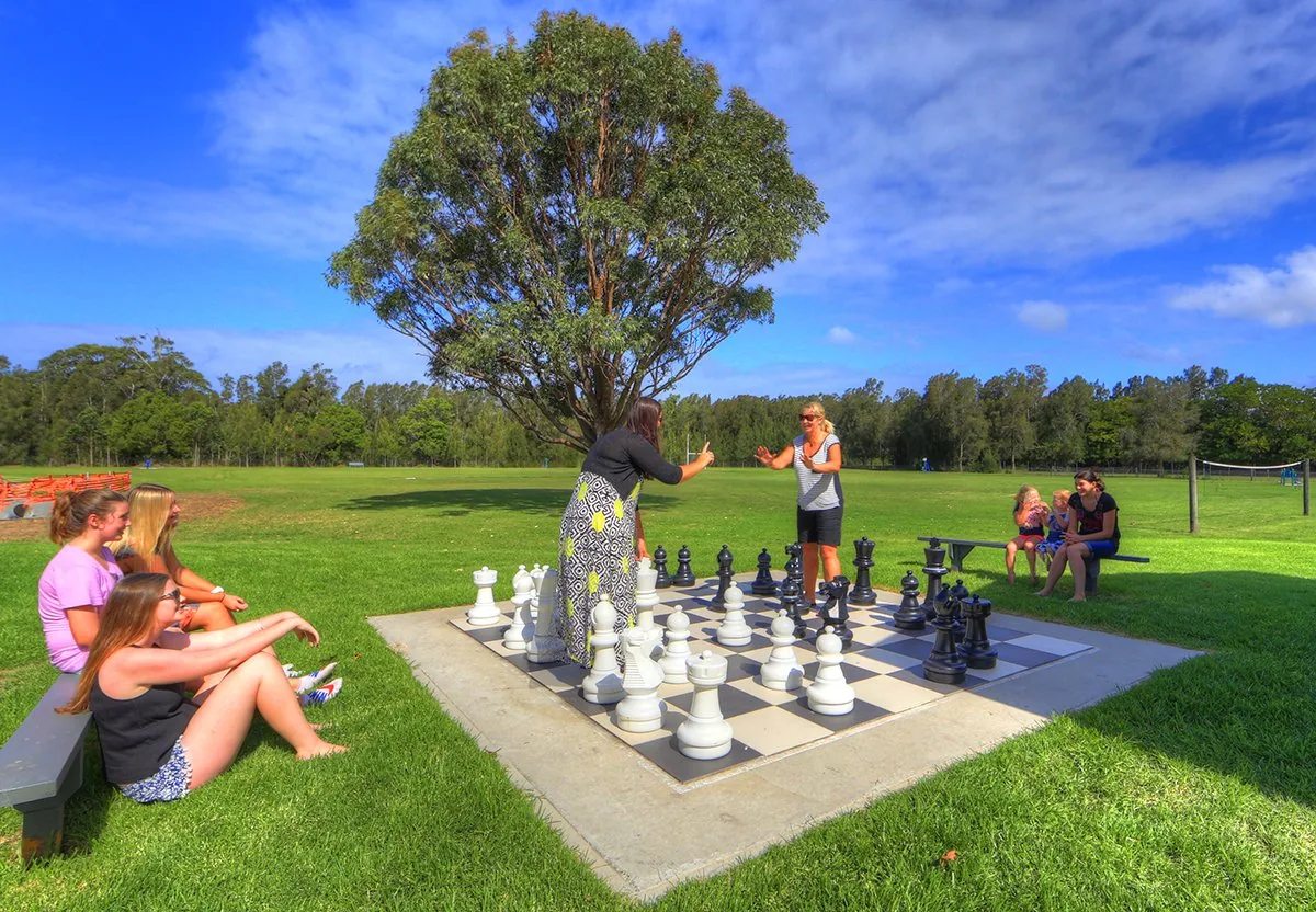 Oversized chess pieces on a board laid out on the lawn